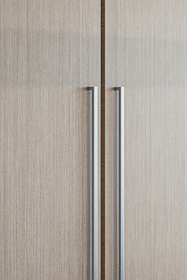 Close-up of light oak kitchen cabinetry with silver hardware