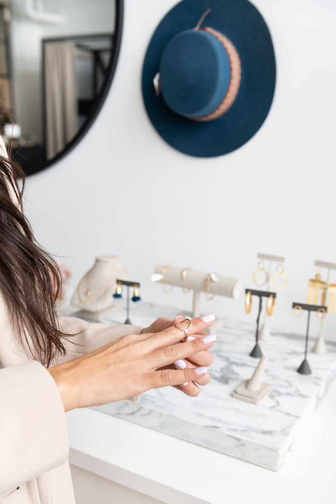 In a high-end retail store, a woman shops for gold jewelry